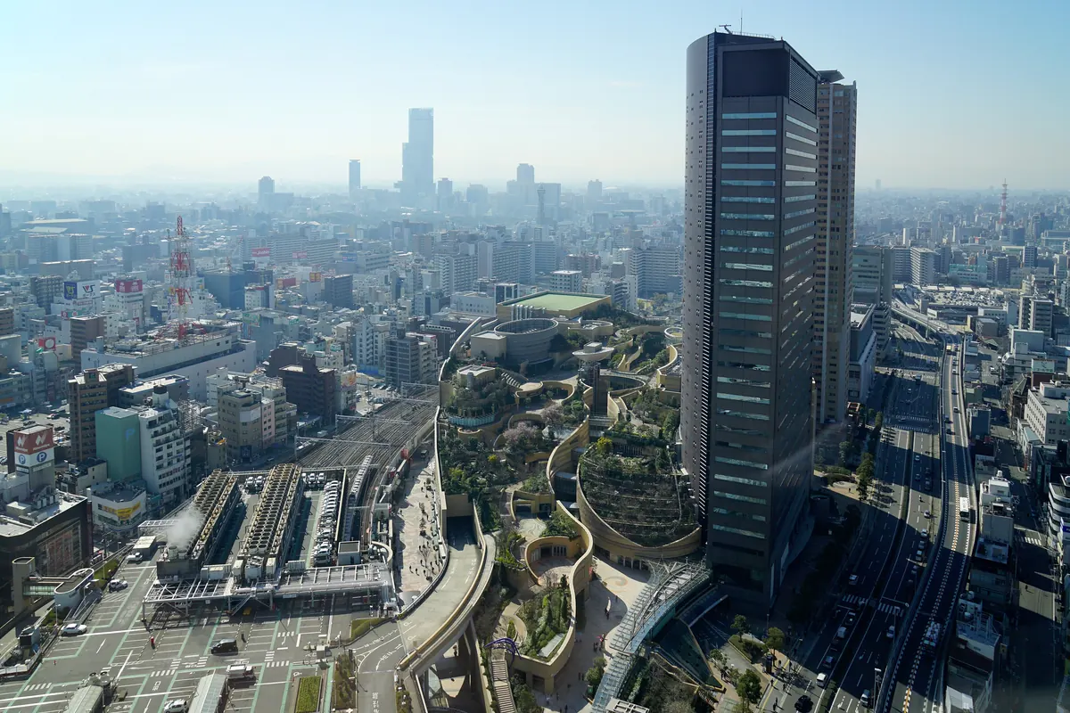 A alta torre de vidro e os jardins suspensos em socalcos do complexo Namba Parks vistos de cima sobre a cidade de Osaka